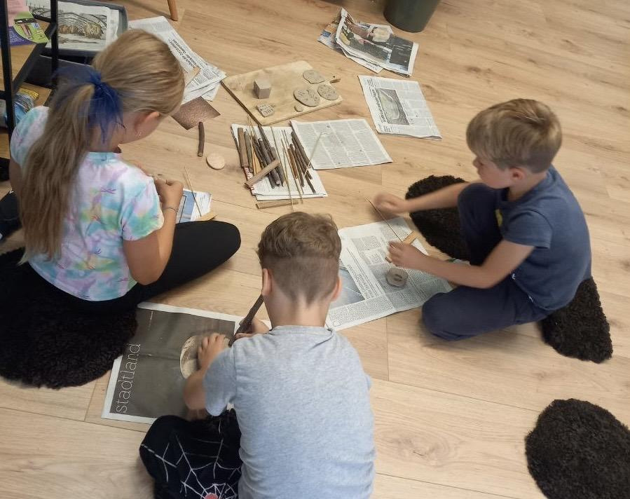 Kinder arbeiten gemeinsam mit Ton-Material in der Lernwerkstatt „DaZ meets Montessori